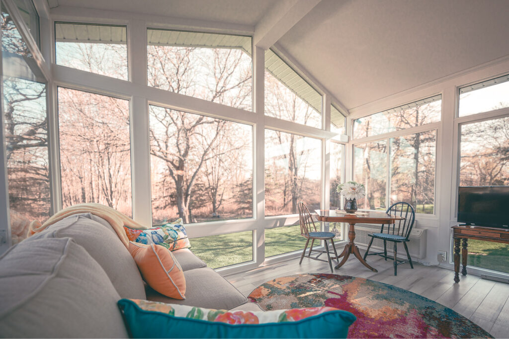 LivingSpace four-season sunroom with glass walls and a wood-plank ceiling